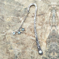 Retro five-pointed star glowing metal bookmark in ancient silver or bronze with sun, moon and stars design