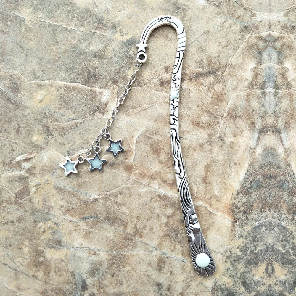 Retro five-pointed star glowing metal bookmark in ancient silver or bronze with sun, moon and stars design