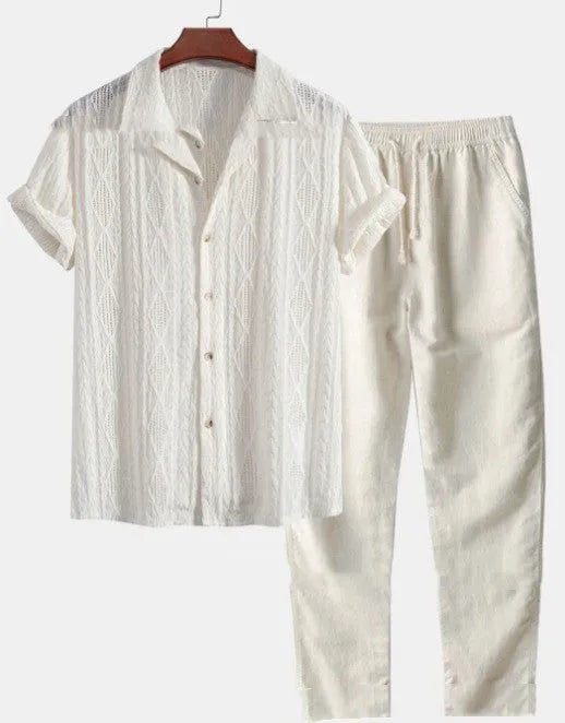 Man wearing a loose light blue short sleeve shirt and matching trousers from a milk silk summer suit.