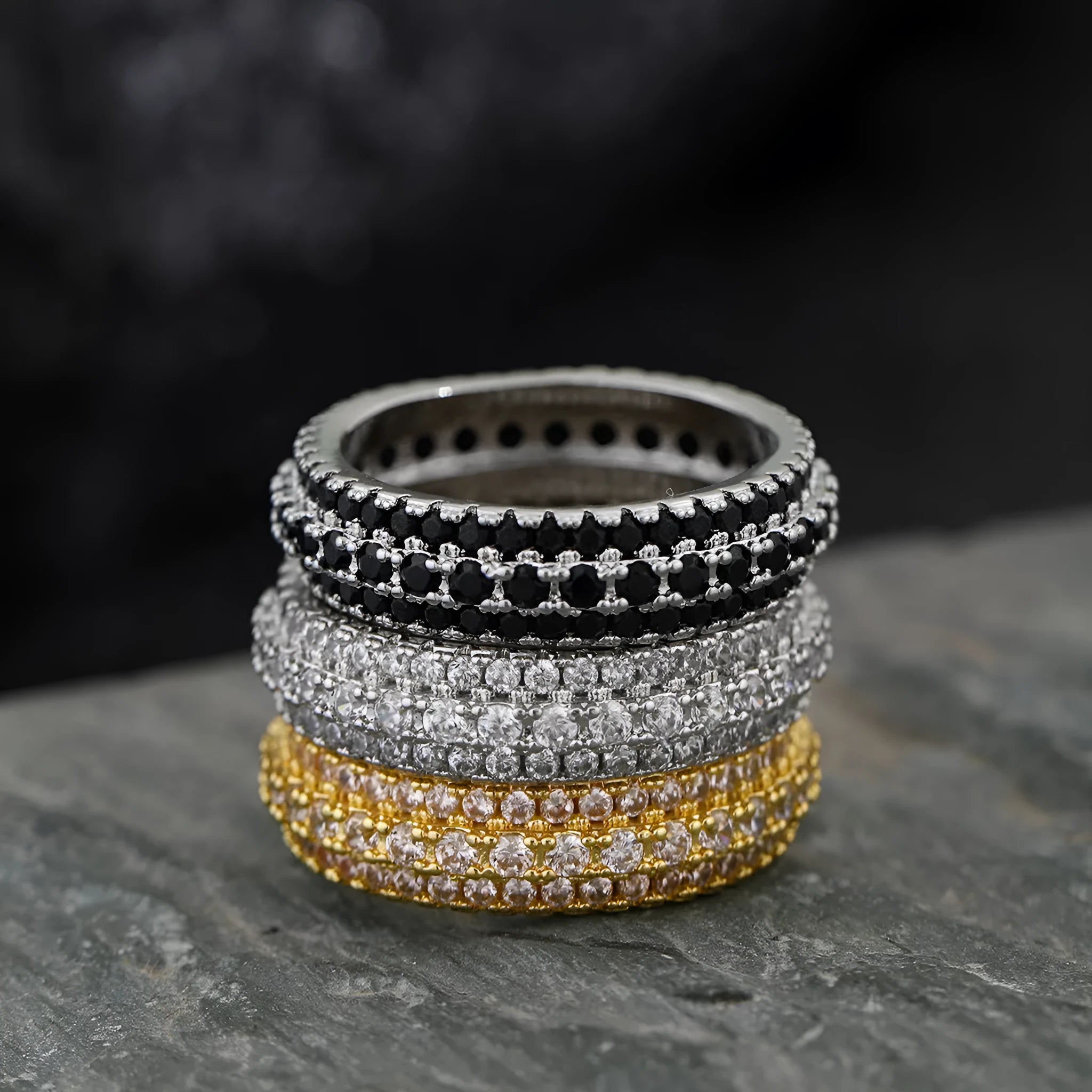 A geometric triangle ring with a zircon inlay, shown in a choice of platinum, yellow gold, or white and black colour.