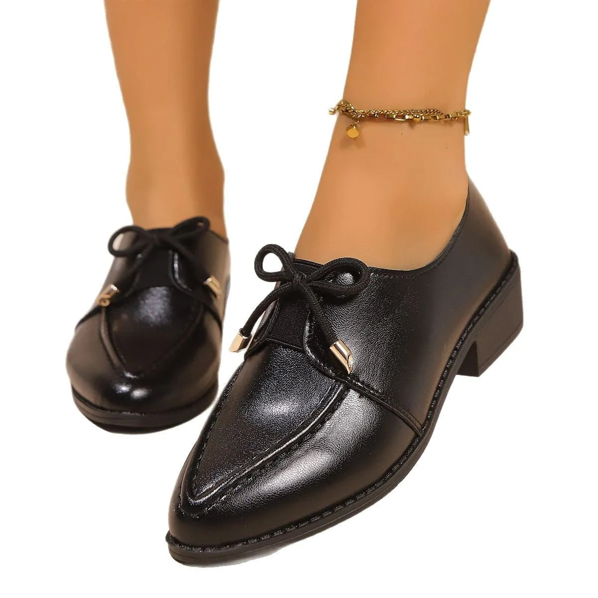 Women's brown leather-look loafers with a large bow detail on the front.