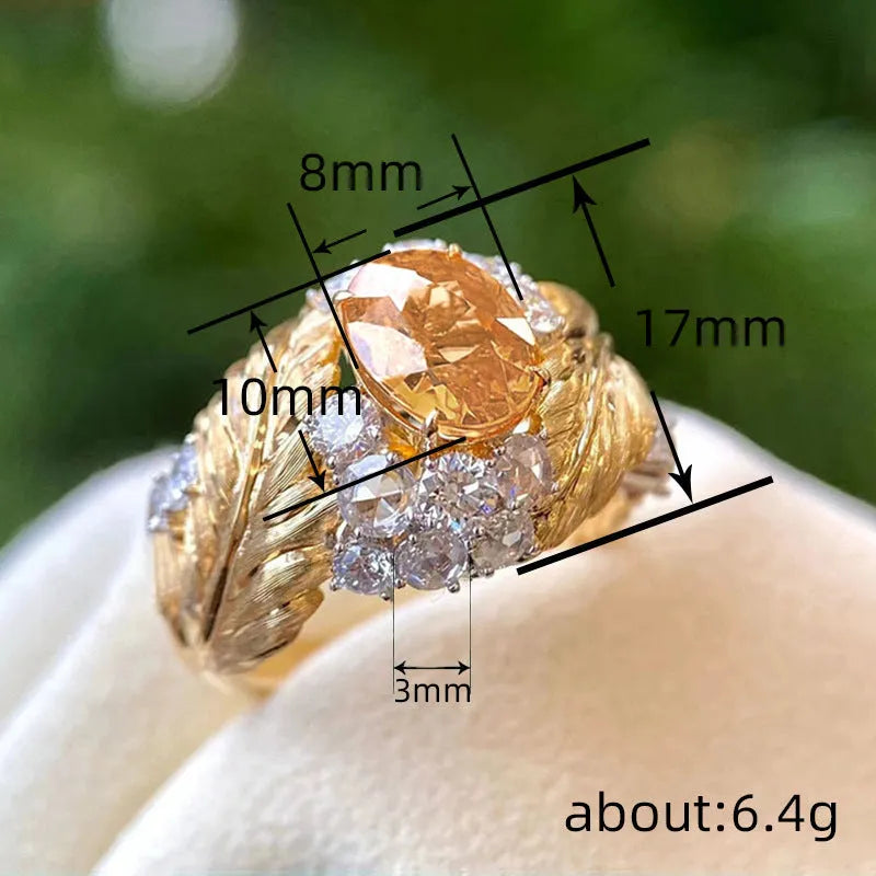 Gold-coloured women's feather ring with embossed design and yellow zircon stones on copper band