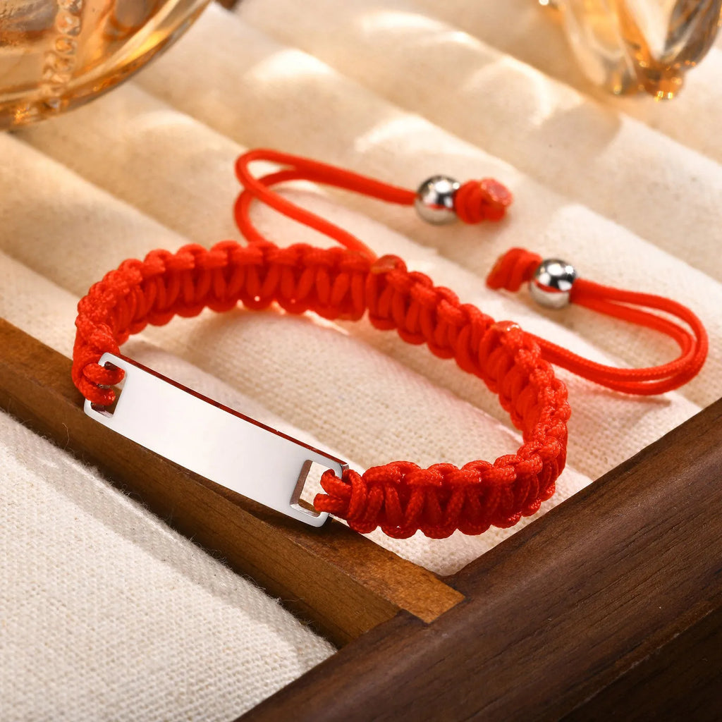 Red nylon rope woven child's bracelet with curved stainless steel brand piece in rose gold finish