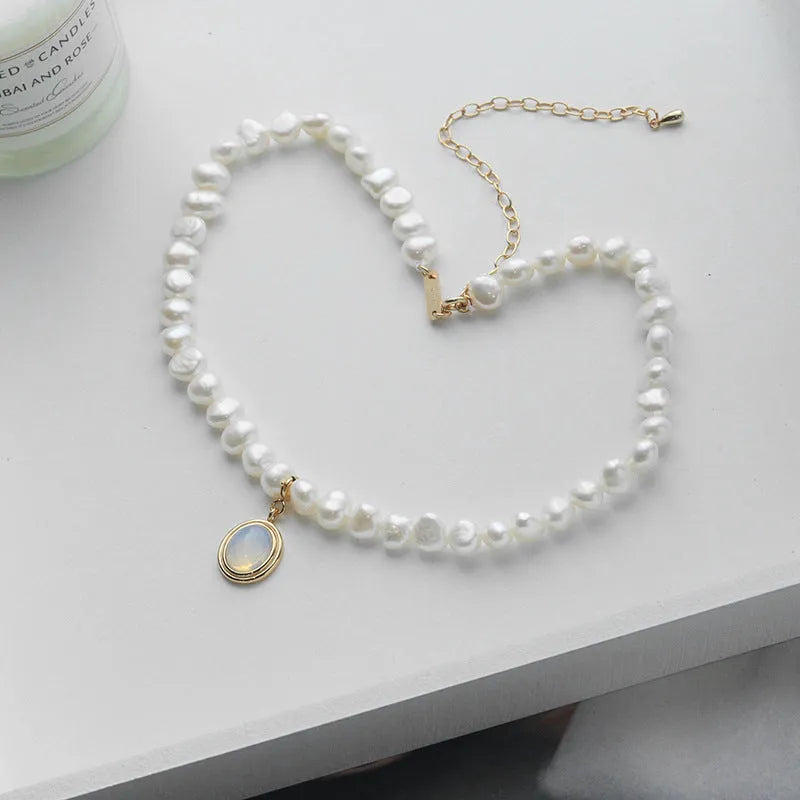 Sterling silver geometric pendant necklace with irregular pearl on adjustable chain.