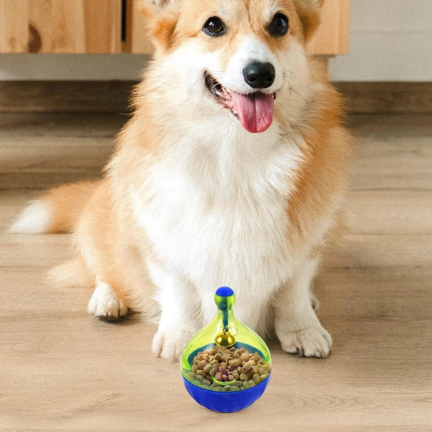 Grey tumbler-shaped interactive pet treat dispenser ball on a wooden floor.
