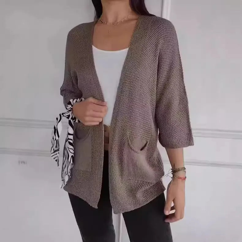 Women's army green waffle texture cardigan coat with nine-quarter sleeves and pockets on a hanger.