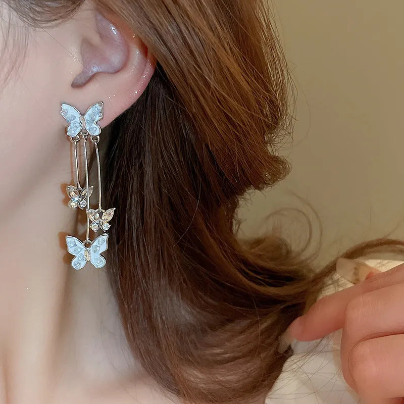 Silver butterfly tassel earrings with blue rhinestone and crystal detail, about 5.7cm long