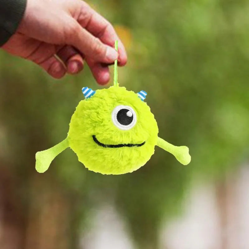 Green sound-activated dog teething toy ball with soft plush exterior for puppy gum massage
