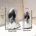 Silver glass ghost decoration with mosaic mirror patch on a desktop for Halloween.