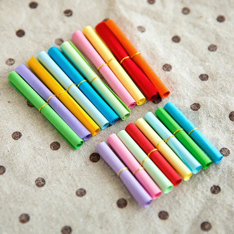 Coloured paper scrolls with metal eyelets in sizes 3x7cm, 4x7cm, 5x5cm, and 7x7cm for message writing.