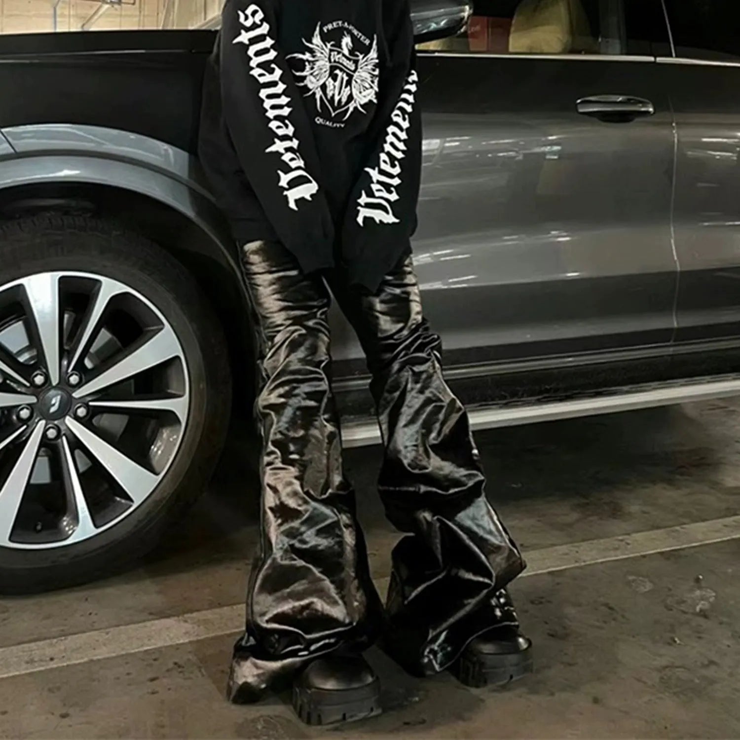 Black coated shiny patent leather straight leg skinny jeans on a hanger.