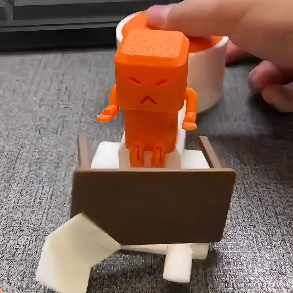 Orange plastic rotating decompression toy on a desk, showing its 16cm length.