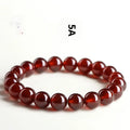 Natural orange red garnet ball bracelet with Ruyi beads on a wrist, showing unisex retro crystal jewellery.