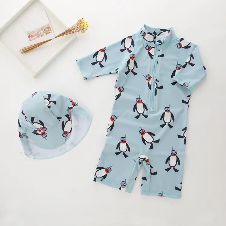 Boy's penguin print long sleeve one-piece swimsuit with matching swimming cap.
