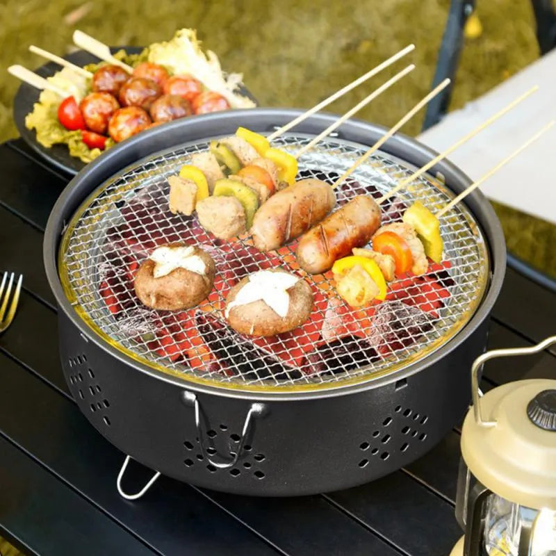 Portable stainless steel charcoal barbecue grill with removable legs and storage bag for outdoor use.
