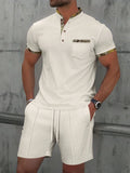 Man modelling a grey waffle knit zip-up polo short sleeve top and matching shorts.