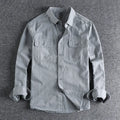 Man wearing a loose-fit light grey polyester cardigan shirt with long sleeves and an overalls design detail.