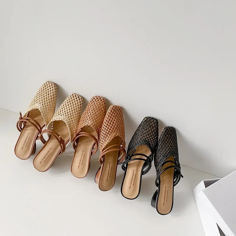 Women's black square toe slippers with hollow-out design and a chunky heel on a rubber sole.