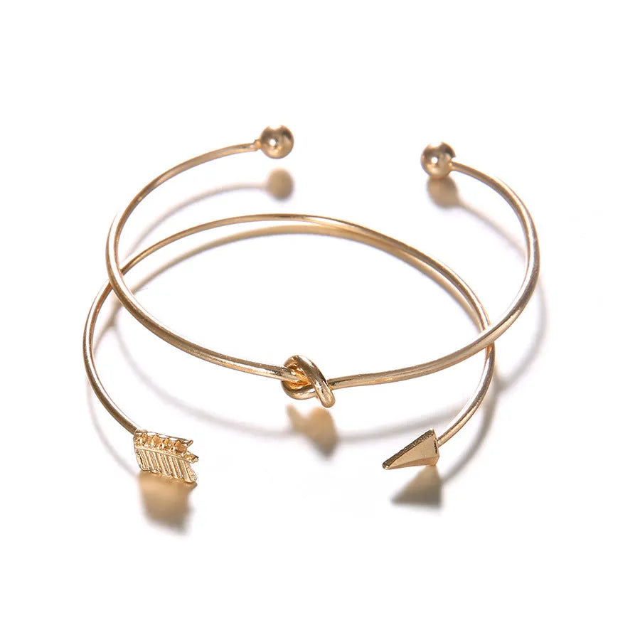 Gold women's cuff bracelet with arrow knot design on alloy electroplated band