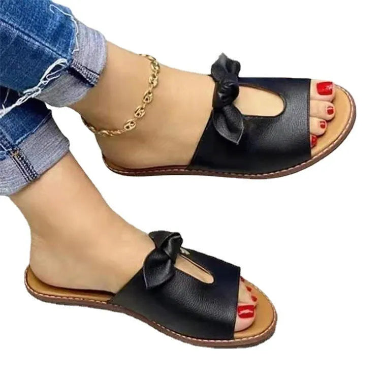 Ladies black sandals with fish mouth open toe and a decorative bow on the strap.