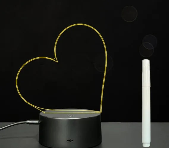 Black 3D acrylic LED night light and message board with stylus on a desktop