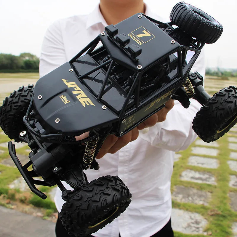 Large black 4WD remote control climbing car and a smaller silver high-speed RC car with wireless remotes