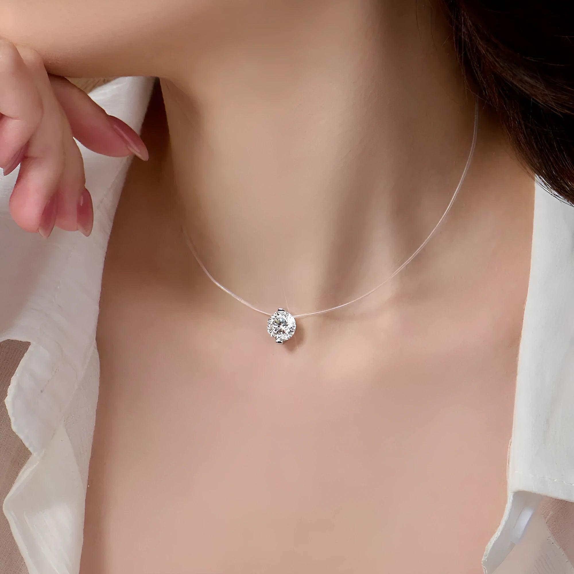 Women's silver pendant necklace with moissanite stone on an invisible fishing line chain.