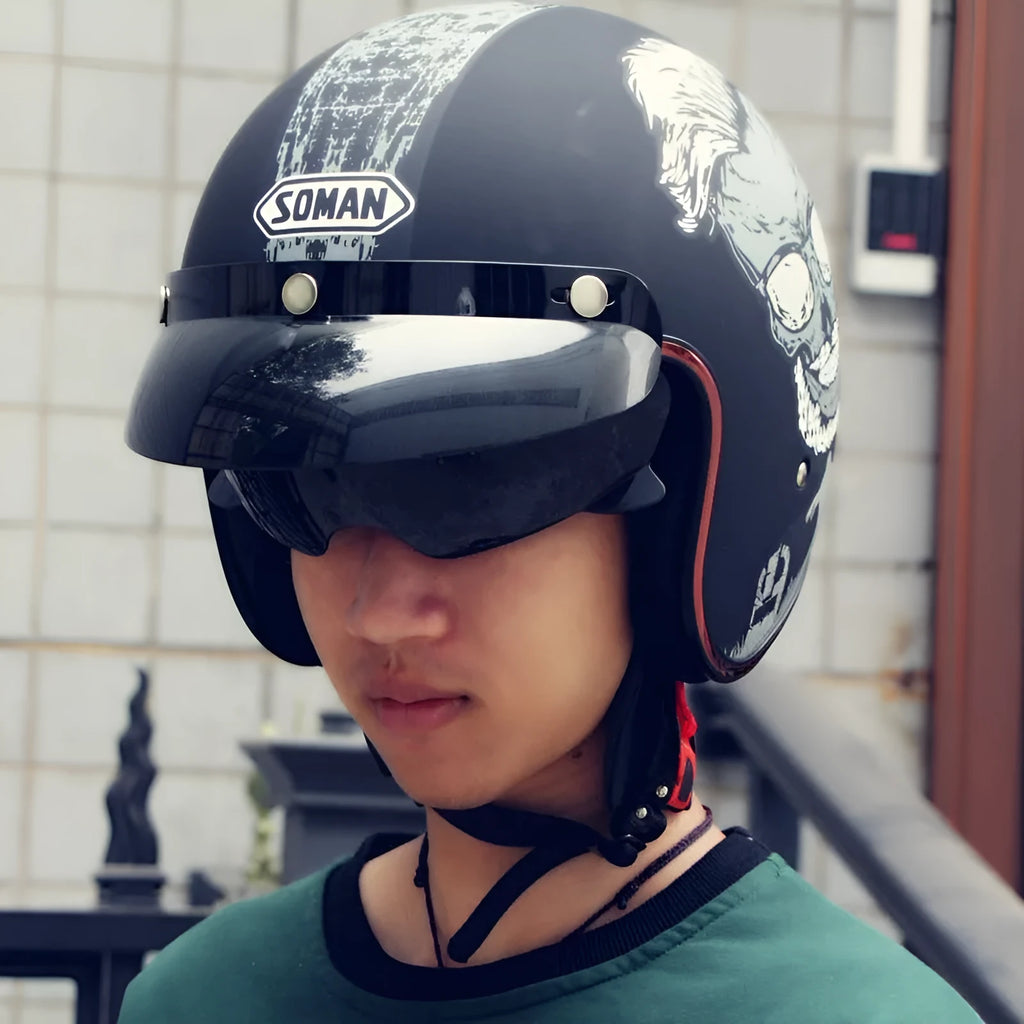 Retro-style black and orange half helmet for electric bike riding on a grey background.