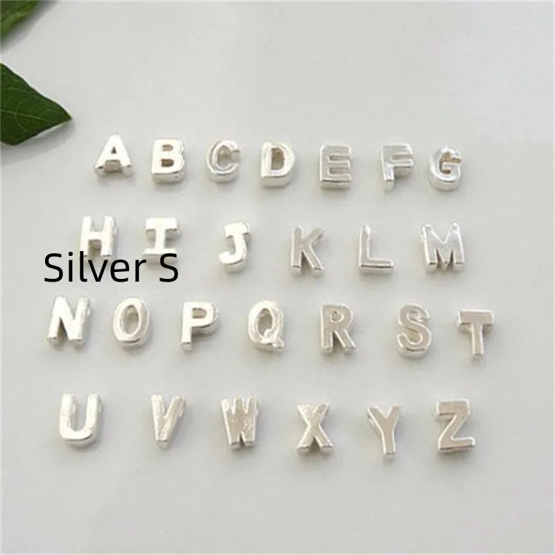Gold heart shaped alloy pendant with initial letter on white background