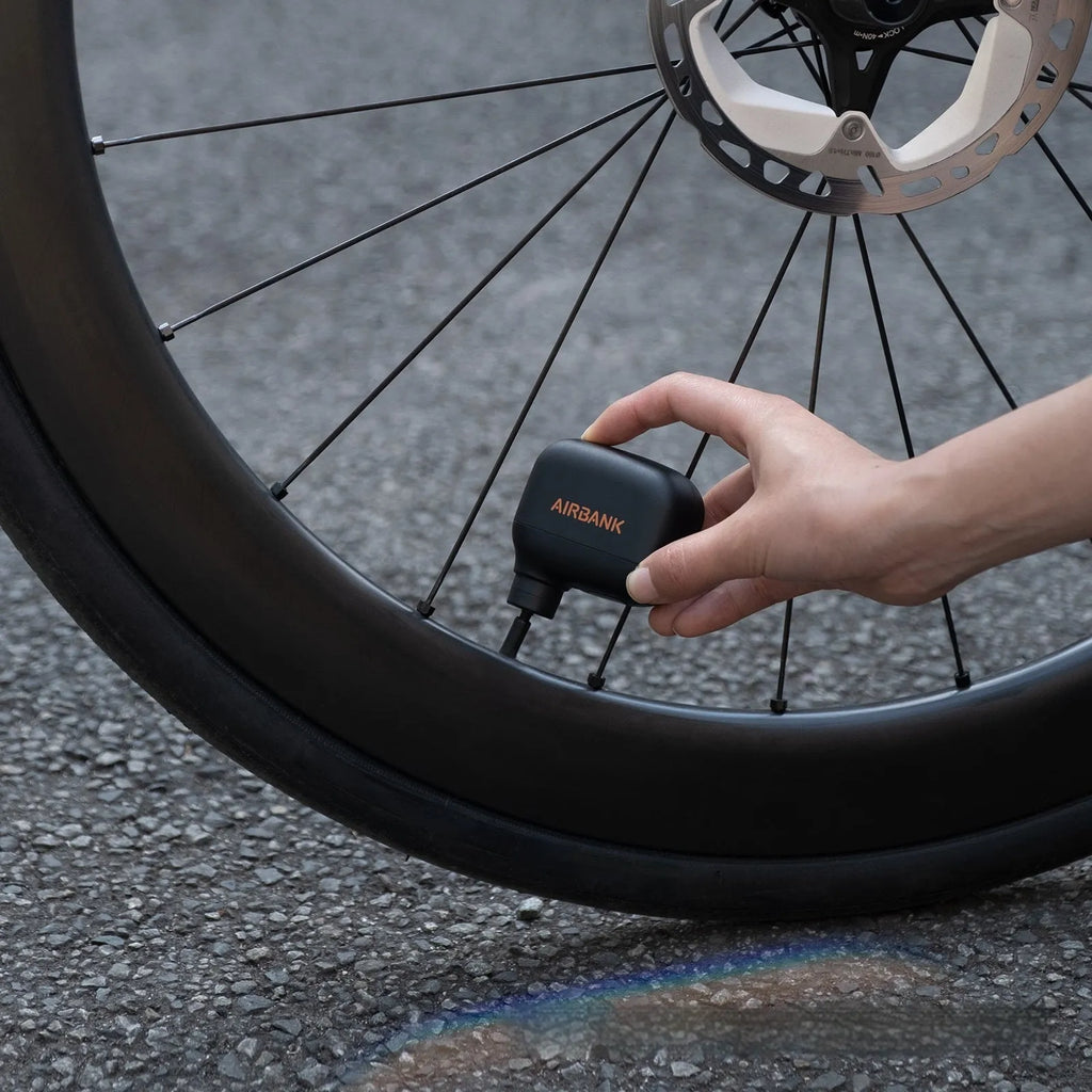 Black plastic USB-rechargeable electric bicycle tyre inflator pump with charging cable and waterproof bag