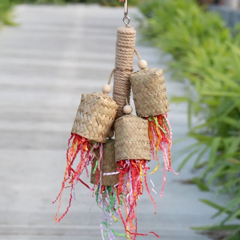 Colourful shredded paper parrot toy on wooden perch with sisal rope attachments