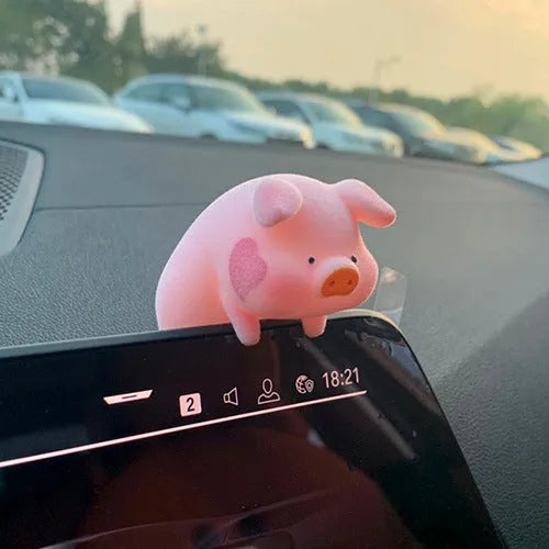 A cute resin cartoon pig figurine car dashboard decoration on a grey background.