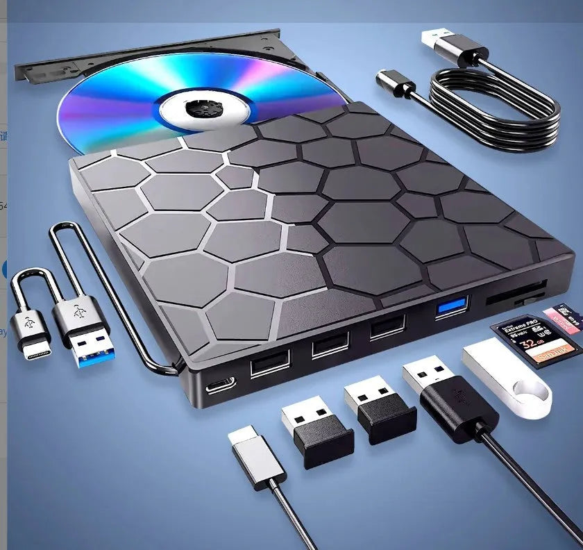 Black aluminium external USB CD drive and writer on a desk next to a laptop.