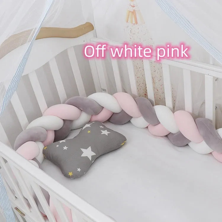 Braided knot design crib bumper in spandex velvet, shown in a light grey colour wrapped around crib slats.