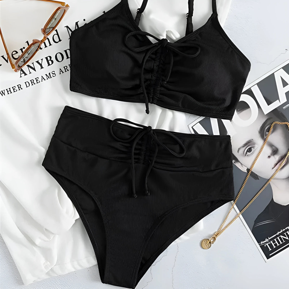 Black women's bikini swimsuit with sling split style and high waist shorts.