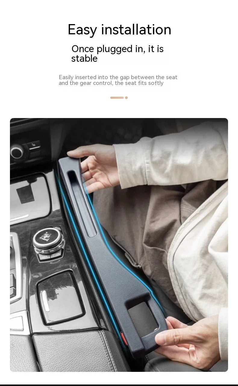 Black plastic car seat gap storage organiser box with a handle, shown inserted between vehicle seats.