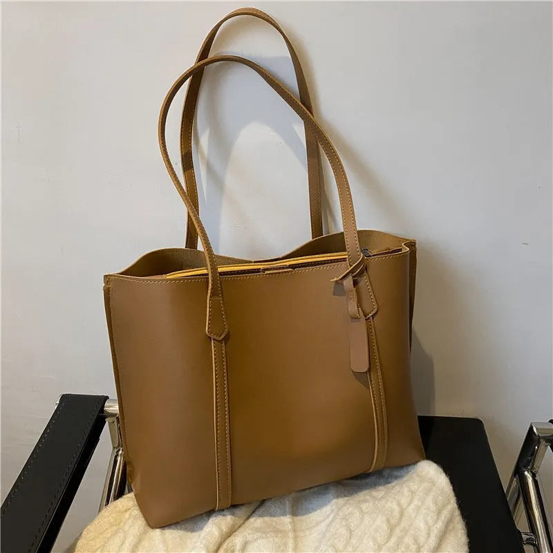 Large capacity soft leather tote bag in beige with synthetic leather lining and double shoulder straps.