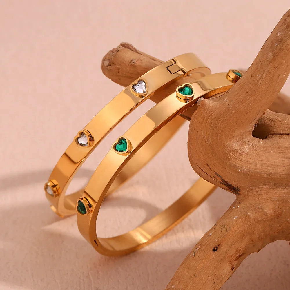 A stainless steel bracelet with a micro-inlaid peach heart charm in green or white diamond colour.