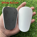Extra small mini plastic football shin guards for kids in black and white, measuring 8 by 5 centimetres.