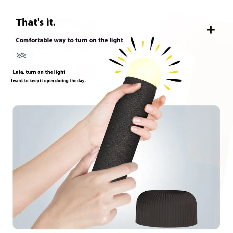 Creative handheld night light with fabric covering on base, emitting warm light