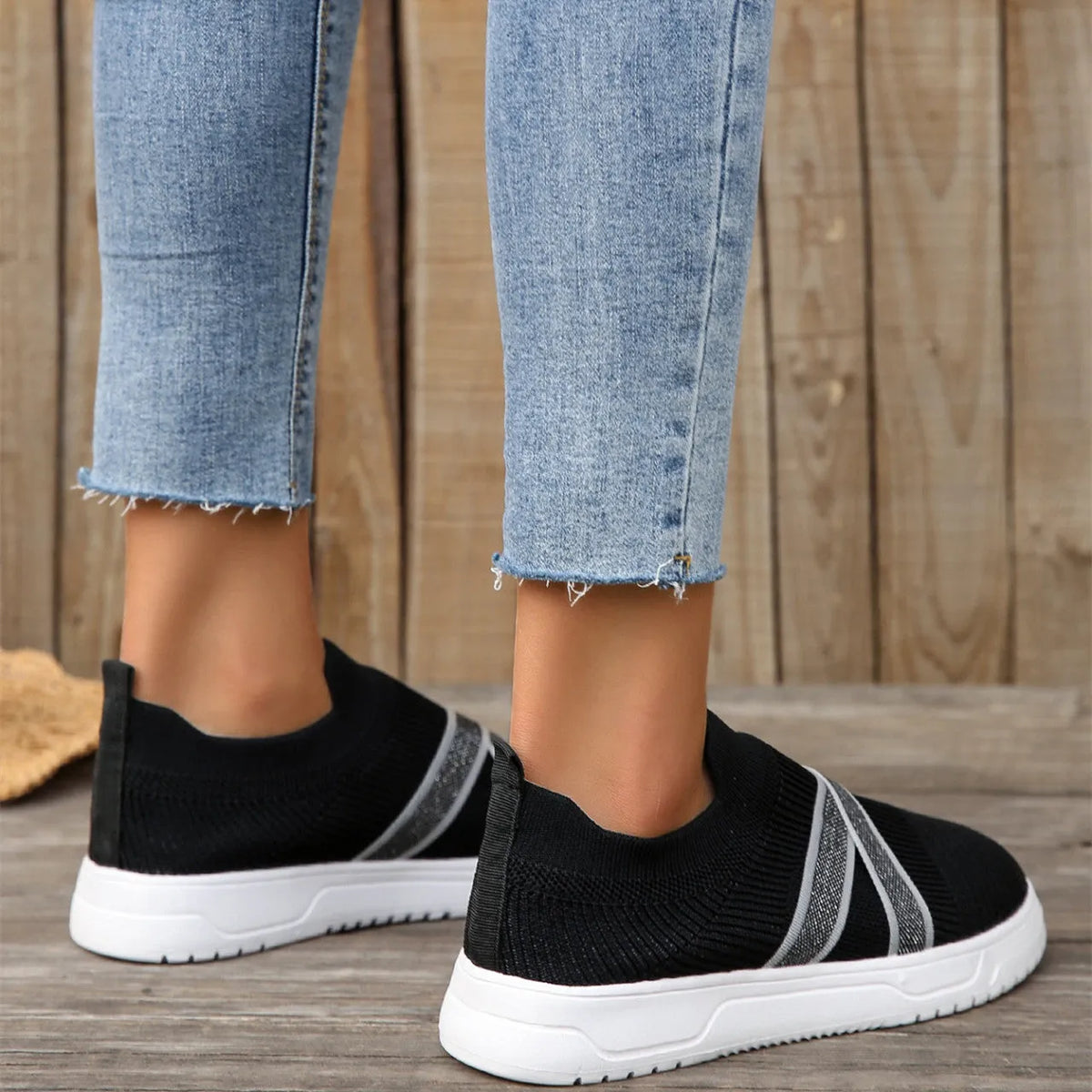 Black women's flat shoes with flyknit mesh upper, round toe, tassel detail, and rubber sole.