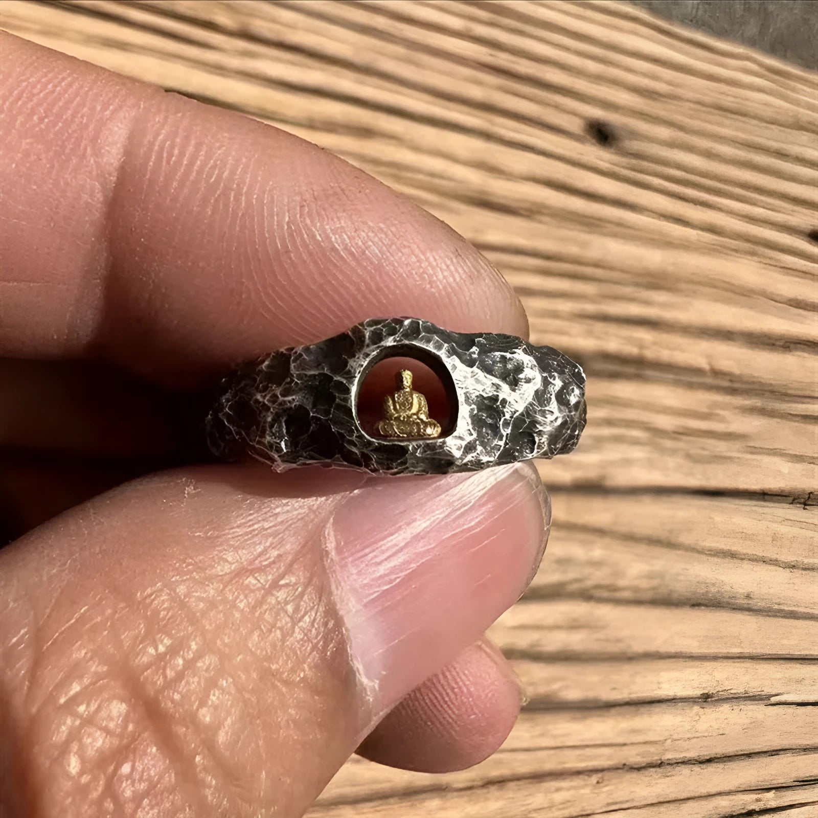 Hand-forged copper Grotto Buddha ring with rock texture on a size 8 finger.