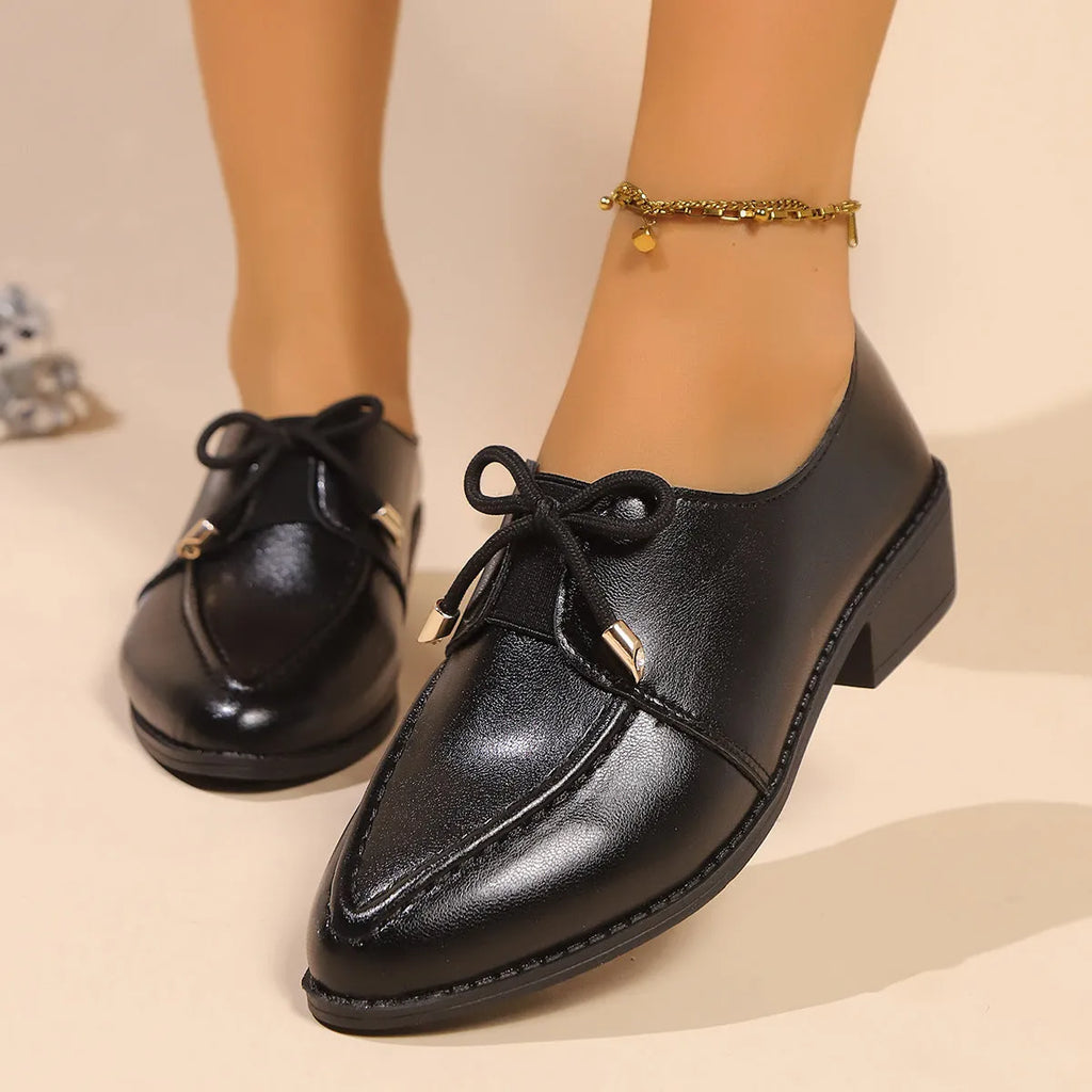 Women's brown leather-look loafers with a large bow detail on the front.