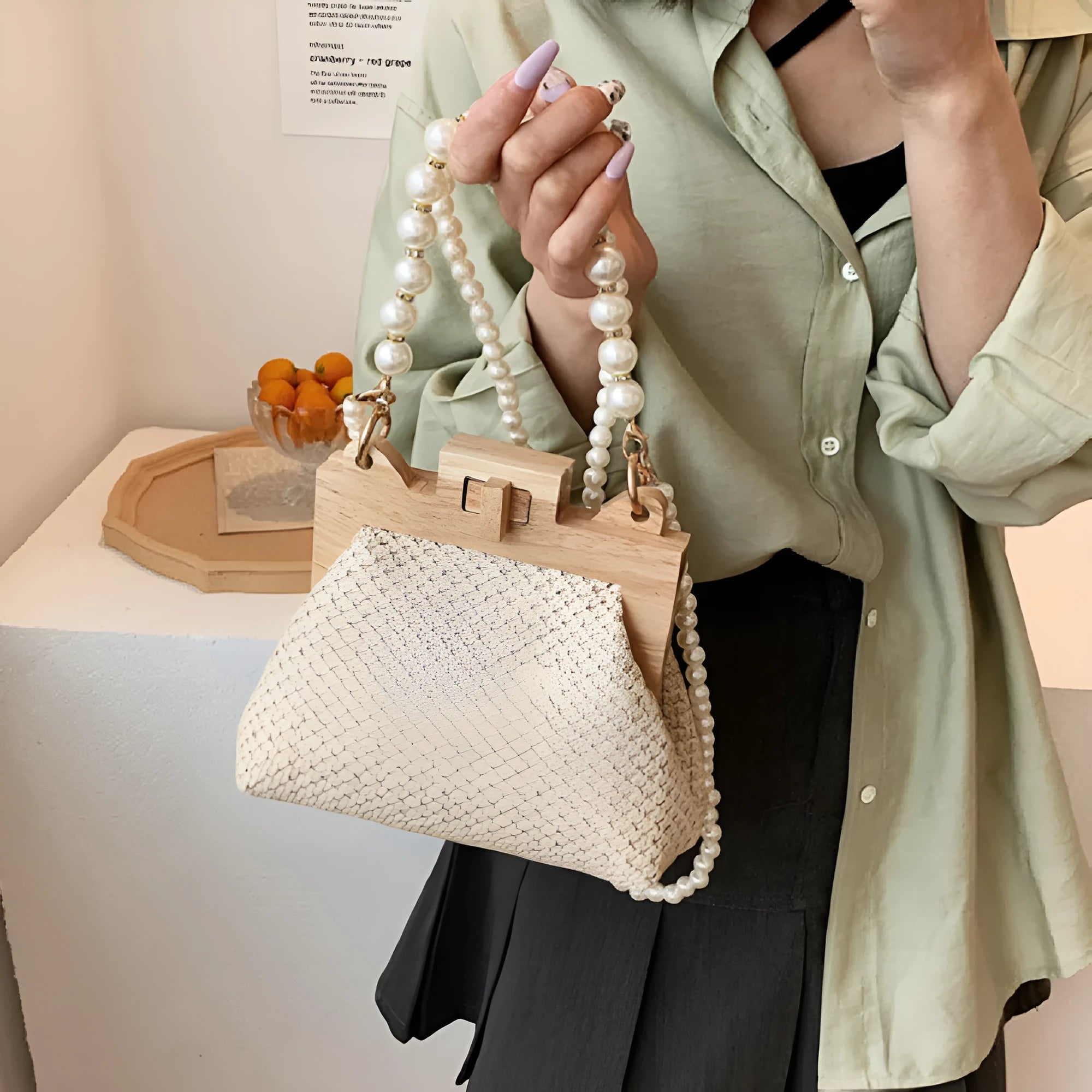 Beige straw woven women's shoulder bag with pearl chain strap showing front view