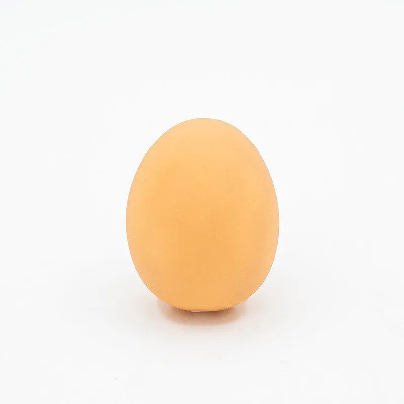 Red and white egg-shaped dog chew toy with textured surface and built-in squeaker