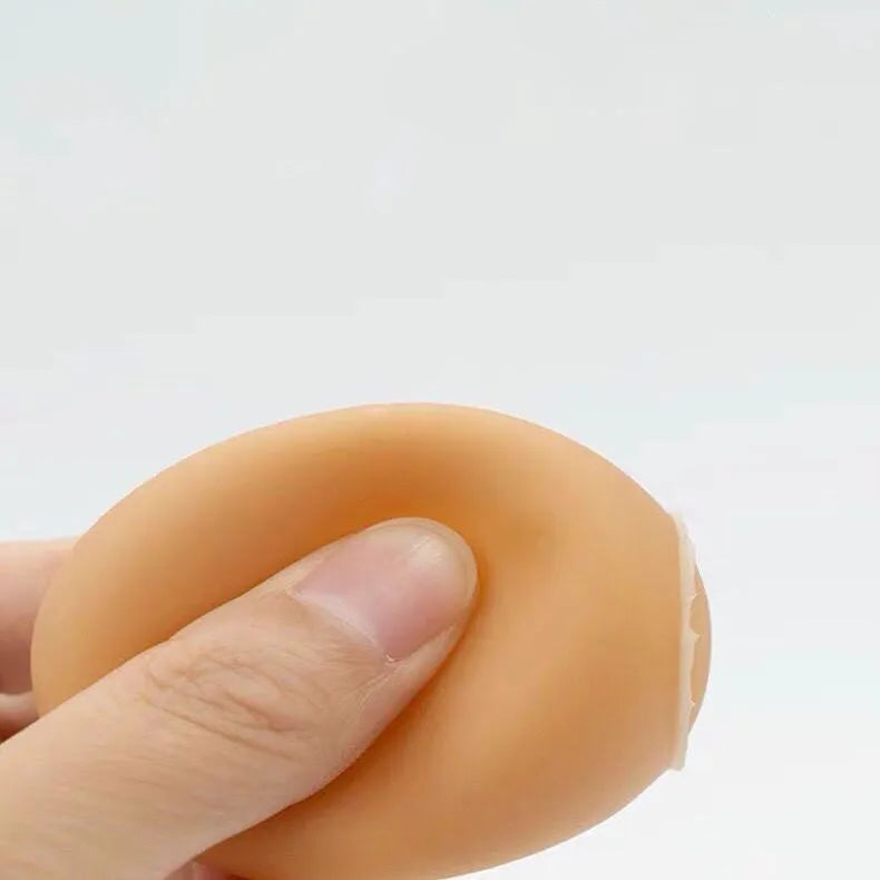 Red and white egg-shaped dog chew toy with textured surface and built-in squeaker