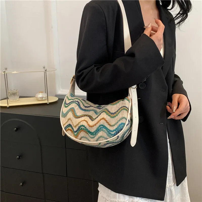 Women's woven straw crossbody bag with a single strap and internal organisation pockets.