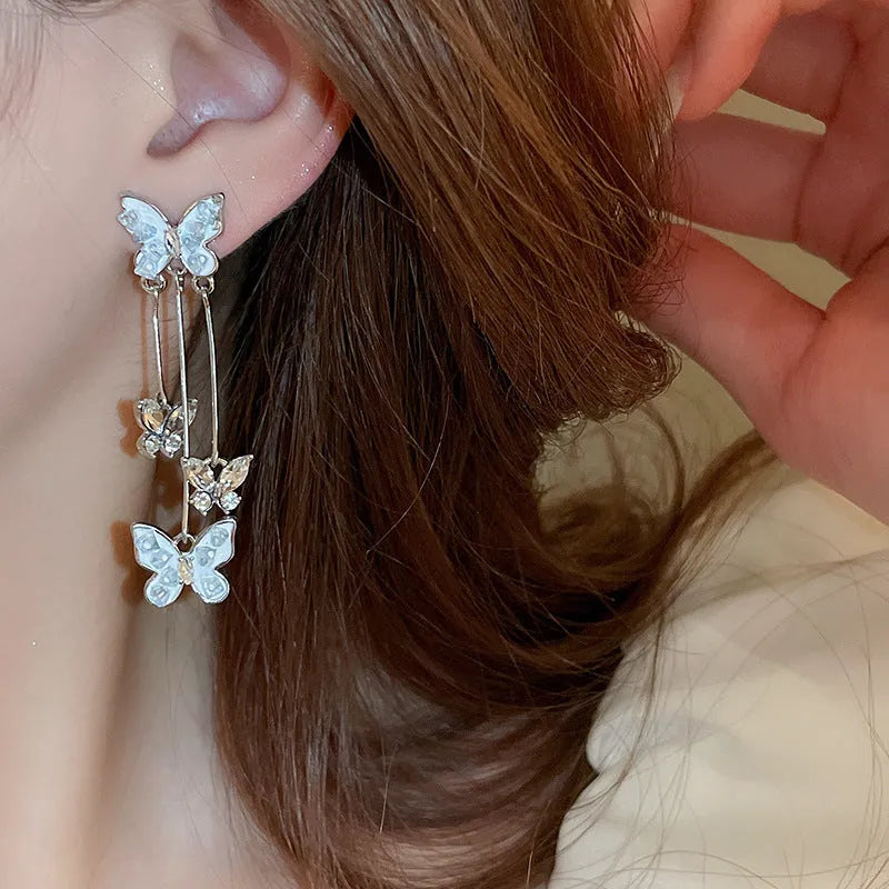 Silver butterfly tassel earrings with blue rhinestone and crystal detail, about 5.7cm long