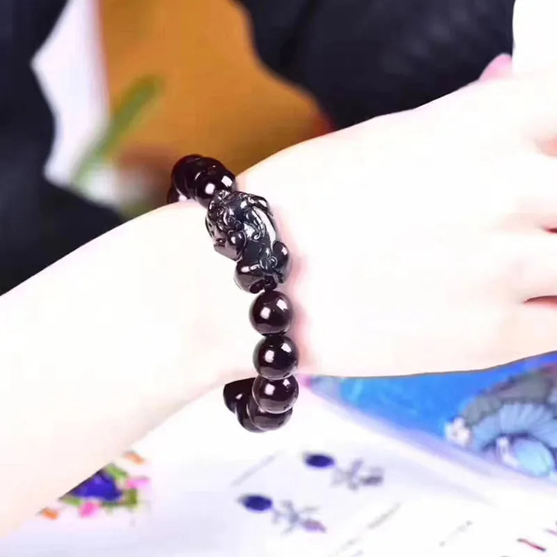 Natural eye obsidian crystal bracelet in ice colour on a wrist, showing bead sizing options.
