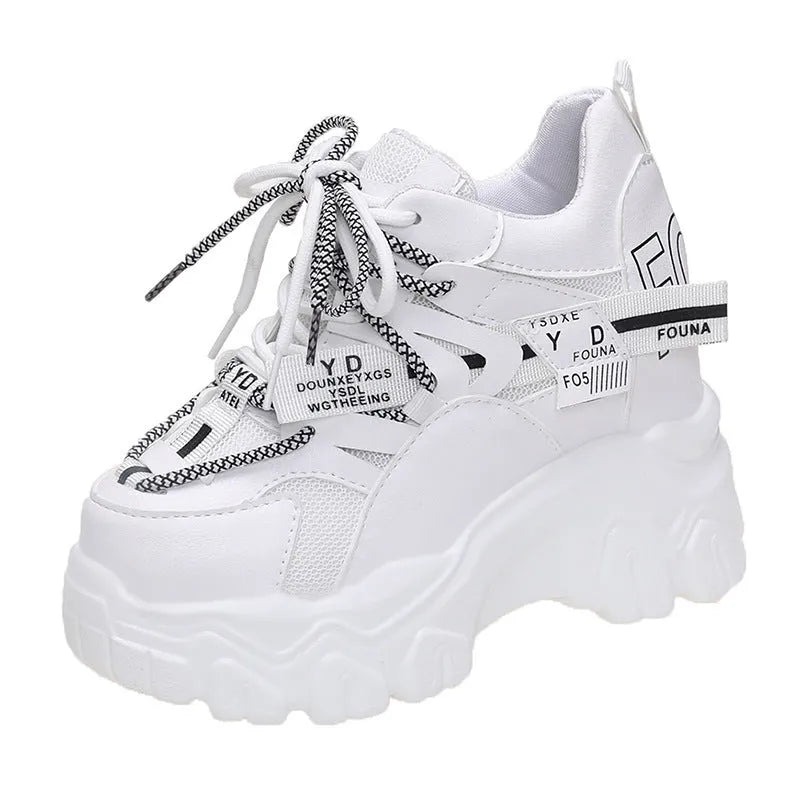Women's white mesh platform trainers with cross-strap and chunky rubber sole on a neutral background.